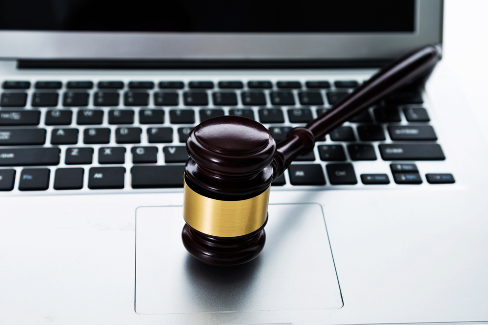 Gavel resting on top of a laptop keyboard.